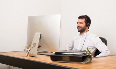 Wall Mural - Telemarketer man in a office posing with arms at hip and laughing looking to the front