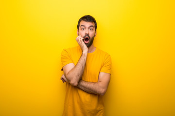 Wall Mural - Man on isolated vibrant yellow color surprised and shocked while looking right