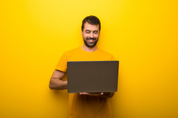 Wall Mural - Man on isolated vibrant yellow color with laptop