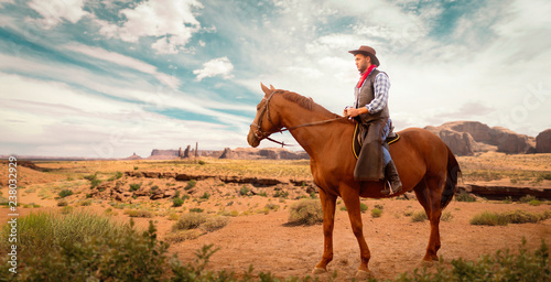 Photographie Cowboy in leather clothes riding a horse, western