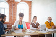 © pressmaster - Casual office workers concentrating on carrying out business tasks such as paperwork and planning