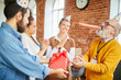 © pressmaster - Group of young managers congratulating their senior boss on anniversary right in office