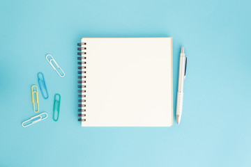 Wall Mural - blank notebook and pen on blue background, flat lay photo of notebook for your tex