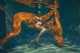 cute sporty girl swims underwater as a free diver in lingerie and mesh catsuit with rhinestones alone