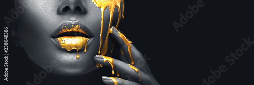 Fotomural Golden paint smudges drips from the face lips and hand, golden liquid drops on beautiful model girl's mouth, creative abstract makeup
