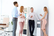 Co-workers having break near water cooler at workplace