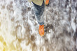 © v_sot - Walk on wet melted ice pavement. View from above on the feet of a man walking along the icy pavement. Pair of shoe on icy road in winter. Abstract empty blank winter weather background