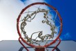 © TenWit - Closeup up basketball hoop looking up from below against a blue cloudy sky