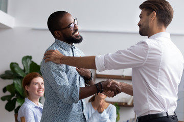 diverse people gathered in meeting executive manager shake hands with black employee impressed by pr