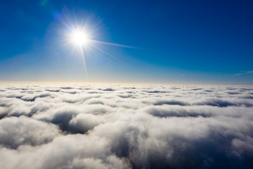 Bright sun over fluffy clouds aerial. Beautiful cloudscape