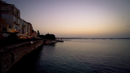 Wall Mural - Sunset over the sea to Sicily, the island of Ortigia.