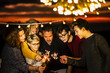 © simona - Group of friends celebrate together christmas night or new year eve or birthday or party like anniversary using sparkles light and having a lot of fun in friendship - mixed generations