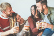 © Alessandro Biascioli - Group of happy friends cheering with beer at home - Millennial Young people having fun drinking and laughing together sitting on sofa - Friendship, entertainment and youth lifestyle holidays