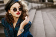 © Victoria Fox - Outdoor fashion portrait of young beautiful fashionable girl wearing trendy sunglasses, wrist watch, earrings, leather beret, blue checkered dress, posing in street, on stairs. Copy, empty space