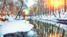 Winter Landscape By A River In The Sunset