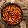 Homemade vegan bolognese sauce made with soy meat, fresh tomatoes, onion and garlic, served in rustic bowl, photographed overhead on rustic wood (Selective Focus, Focus on the sauce)