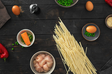 Wall Mural - Raw ingredients cooking udon noodles chicken meat dark wooden table top view