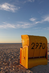 Wall Mural - Beach chair on the East Frisian Island Juist in the North Sea, Germany, in evening light before sunset.