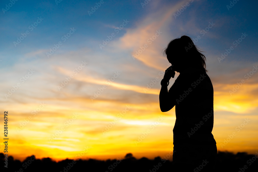 Silhouette woman standing sad in the sunset. Stock Photo | Adobe Stock
