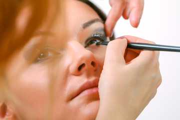 Professional Make-up artist doing glamour model makeup at work