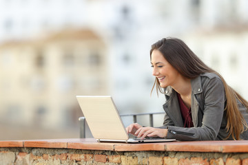 Sticker - Happy woman using a laptop in a terrace