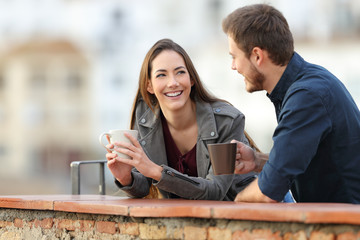 Wall Mural - Couple or friends talking in a terrace drinking coffee