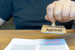 © gabort - Close-up Of Person Hands Using Stamper On Document With The Text Approved