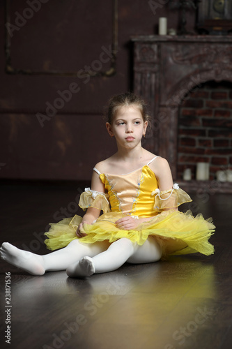 Fotografía brunette girl in a yellow ballet dress sitting