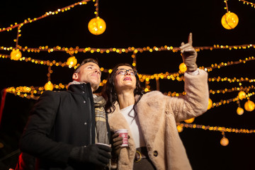 Wall Mural - Couple pointing to decoration at Christmas market. Zagreb, Croatia.