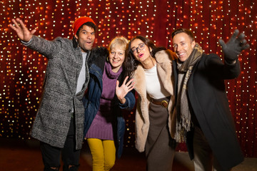 Wall Mural - Group of friends posing for photo at Christmas market.