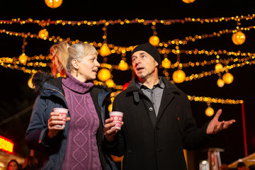 Wall Mural - Couple talking at Christmas market. Zagreb, Croatia.