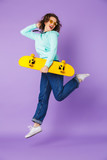 Beautiful young woman posing isolated over purple background wall.