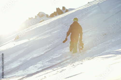 Fotografía A snowboarder with a board rises up the snow-covered mountain slope
