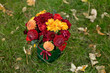 Flower arrangement in a box, a pot with pink, red, orange, marsala for a girl as a gift with roses, asters, freesia, Eucalyptus on a background of lawn and greenery