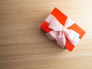 Gift box with bow on wooden background