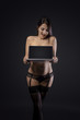 © Vitte Yevhen - Sexy young brunette woman in black sensual lingerie using laptop and posing on black background wall in studio.