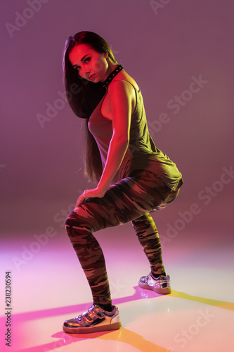 Fotografie, Obraz Attractive young brunette woman in the studio dancing Booty dance on a dark back
