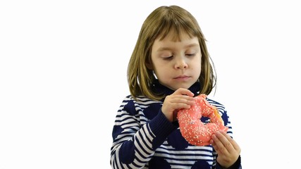 Little girl is eating a donut on a white background.