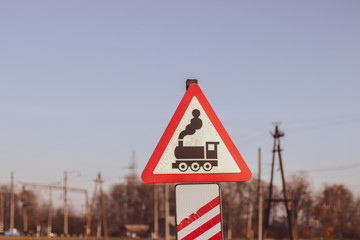 Watch the train. Railroad crossing signs and composition of railway wagons