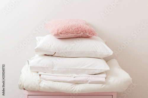 Fotografía A pile of clean ironed bedding and a towel lies on the dresser.
