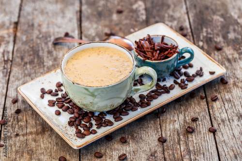 Fotografie, Obraz Oatmeal porridge with coffe and grated chocolate on bright wooden table