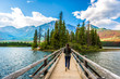 Woman walking along footbridge in Jasper National Park, Canada
