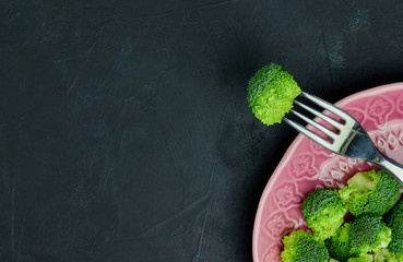 Healthy food Fresh broccoli on a plate on a black background. view from above. copy space.