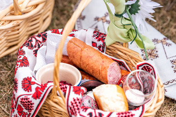 Wall Mural - Russian Orthodox Easter blessing wicker straw basket with sausage meat, nobody on grass ground outside at church, flowers