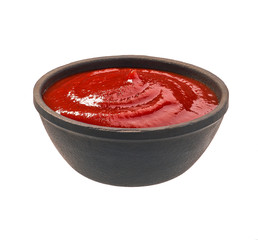 Ketchup in  black bowl isolated on white background