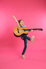 Cute little girl playing guitar on color background