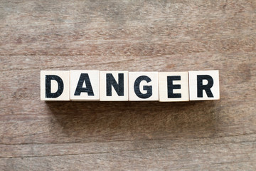 Sticker - Letter block in word danger on wood background