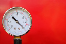 Close Up Water Pressure Gauge On Red Background.