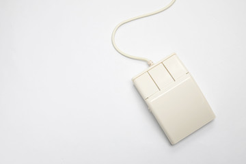 Retro white three-button computer mouse on a white background with copy space. Top view of an old-fashioned input device without scroll wheel.