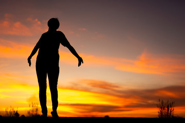 Wall Mural - Young woman relaxing in winter sunset sky outdoor.